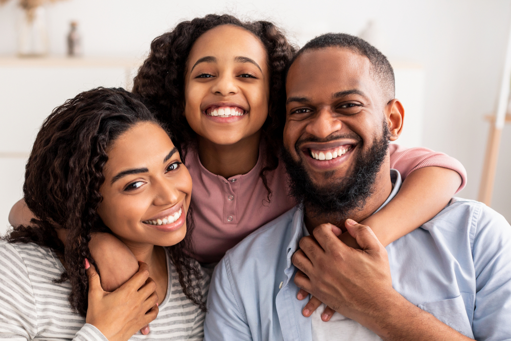 cheerful family of three people hugging